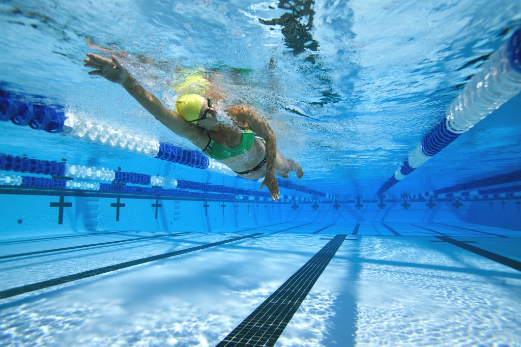 Triathlete Sheri Lehmer swims underwater in pool at Juniper Swim and Fitness Center in Bend, Oregon