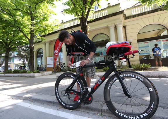 A race participant sticks his number to his bike ahead of the Challenge Triathlon Rimini on May 10, 2014 in Rimini, Italy. (Photo by Charlie Crowhurst/Getty Images for Challenge Triathlon)