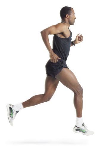 a male african american runner wearing black shorts and shirt is running in profile to the camera