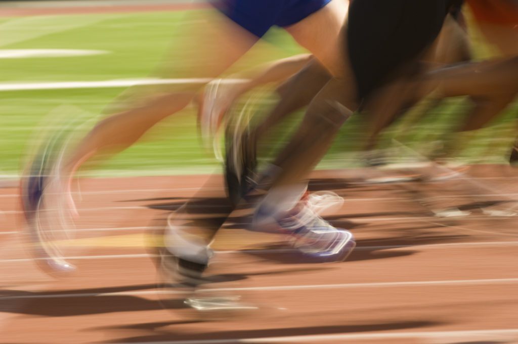 Low section of runners running on a track